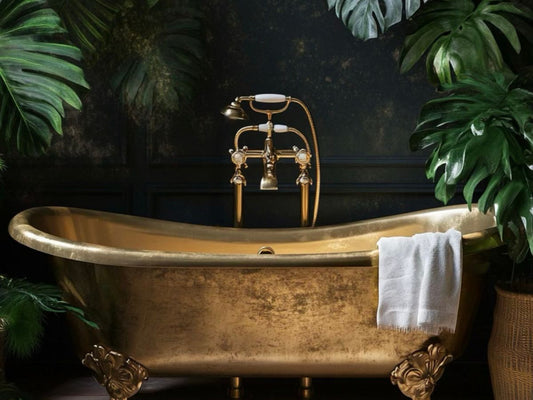 An opulent brass Victorian bathtub surrounded by tropical leaves in the Southeast Asian tropical rainforest.