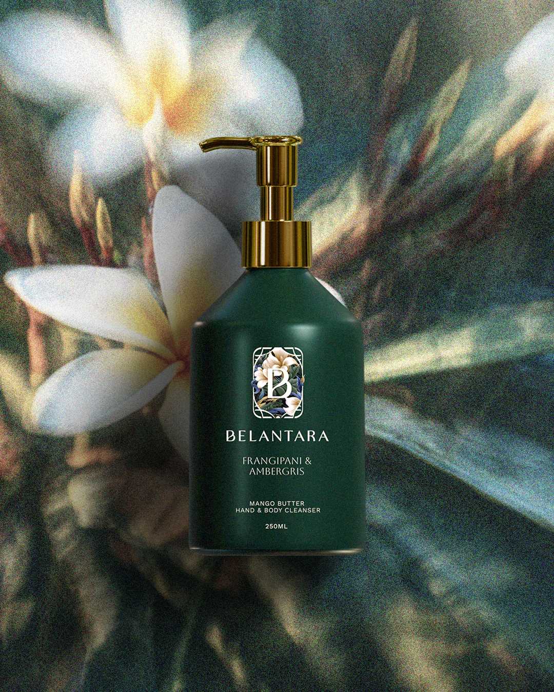 Green bottle with gold pump of Belantara Mango Butter Hand & Body Cleanser in Frangipani & Ambergris fragrance on a textured frangipani background.
