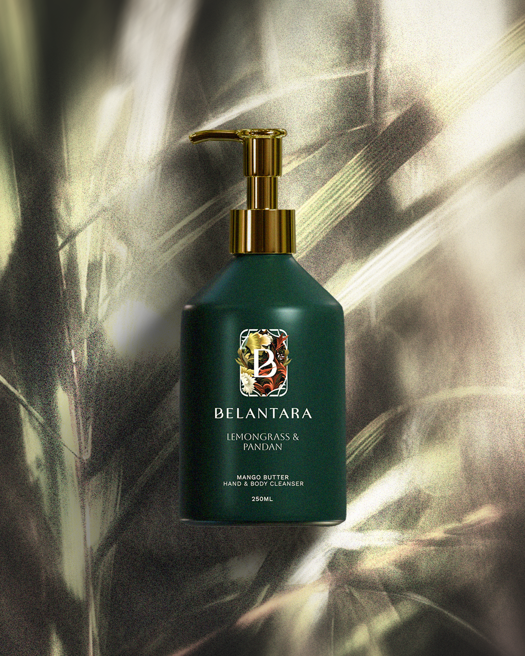 Green bottle with gold pump of Belantara Mango Butter Hand & Body Cleanser in Lemongrass & Pandan fragrance on a textured green background.