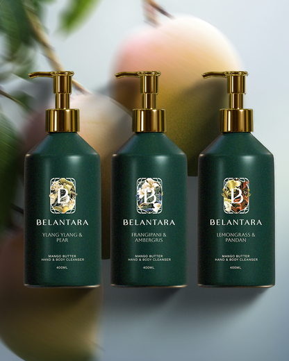 Three green bottle with gold pump of Belantara Mango Butter Hand & Body Cleanser on a textured mangoes background.