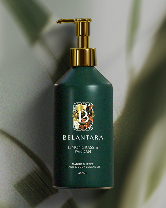 Green bottle with gold pump of Belantara Mango Butter Hand & Body Cleanser in Lemongrass & Pandan fragrance on a textured green background.