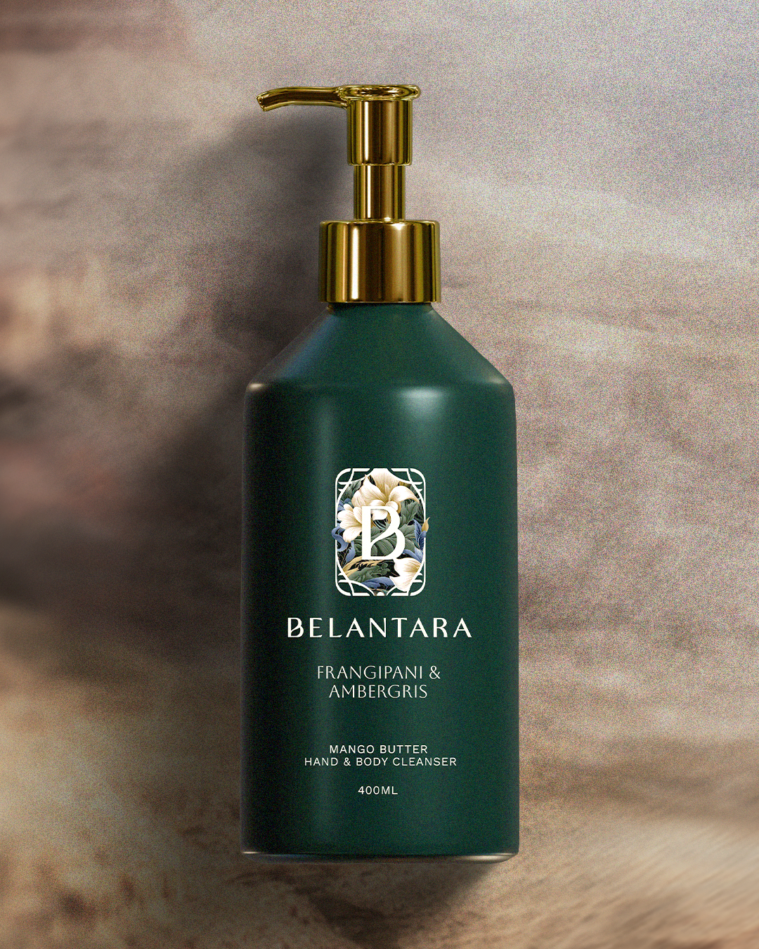 Green bottle with gold pump of Belantara Mango Butter Hand & Body Cleanser in Frangipani & Ambergris fragrance on a textured brown background.